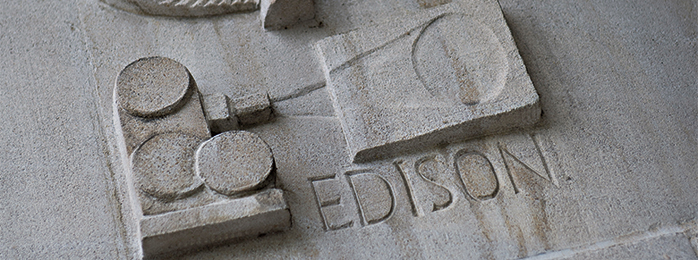 sculpture of film projector with Edison's name in stone