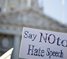 A sign saying Say No To Hate Speech in front of a capitol building