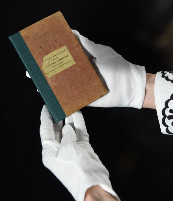 gloved hands holding an old book